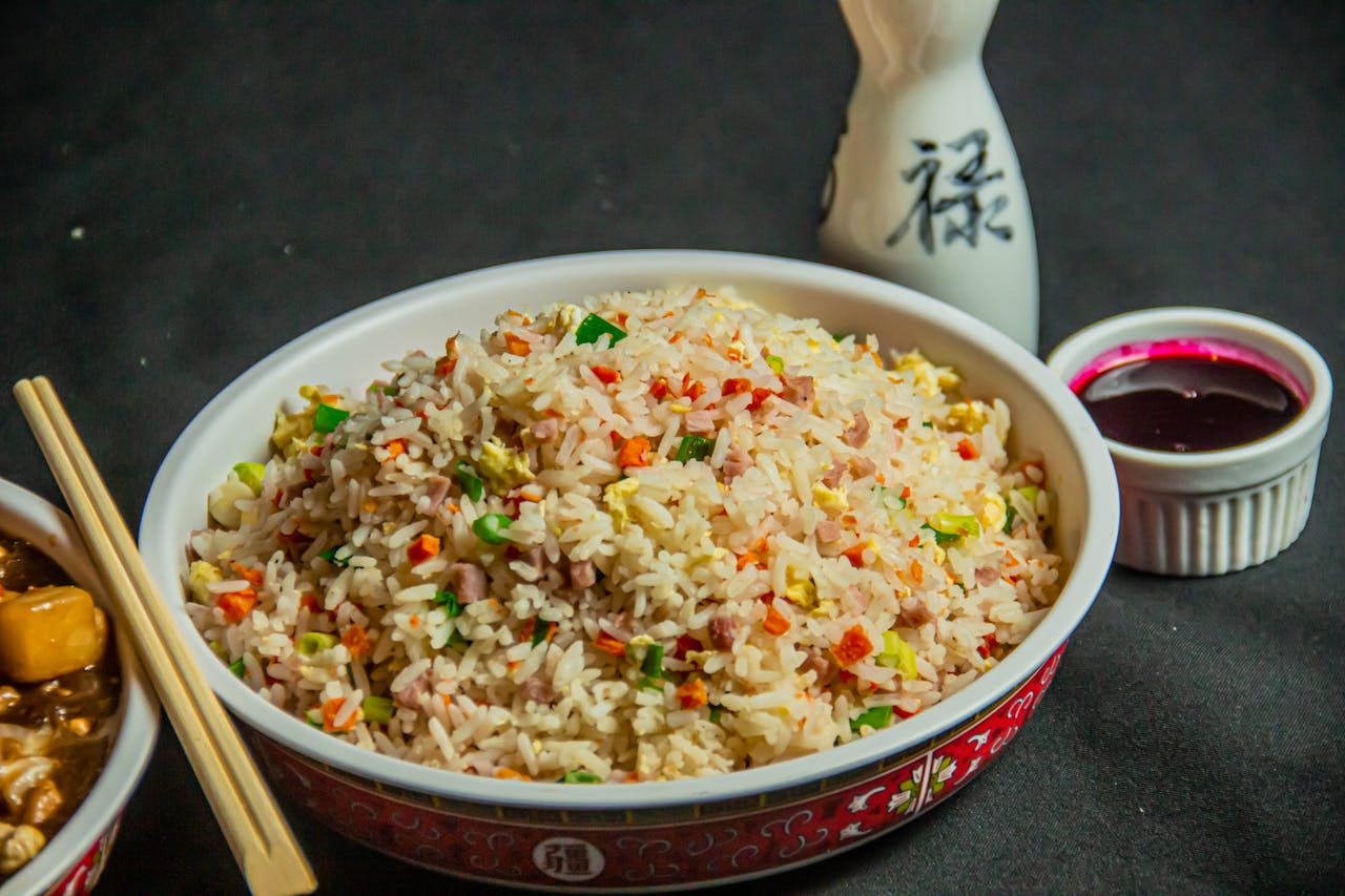 A vibrant bowl of Asian-style fried rice served with traditional condiments for a mouthwatering experience.