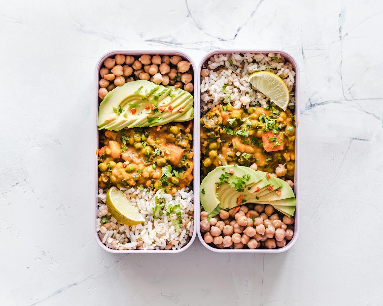 수원 밤공기와 잘 어울리는 집, 아시아와 서양이 한 상에서 만나는 순간 Delicious vegan lunchboxes featuring chickpeas, rice, avocado, and curry on a white background.